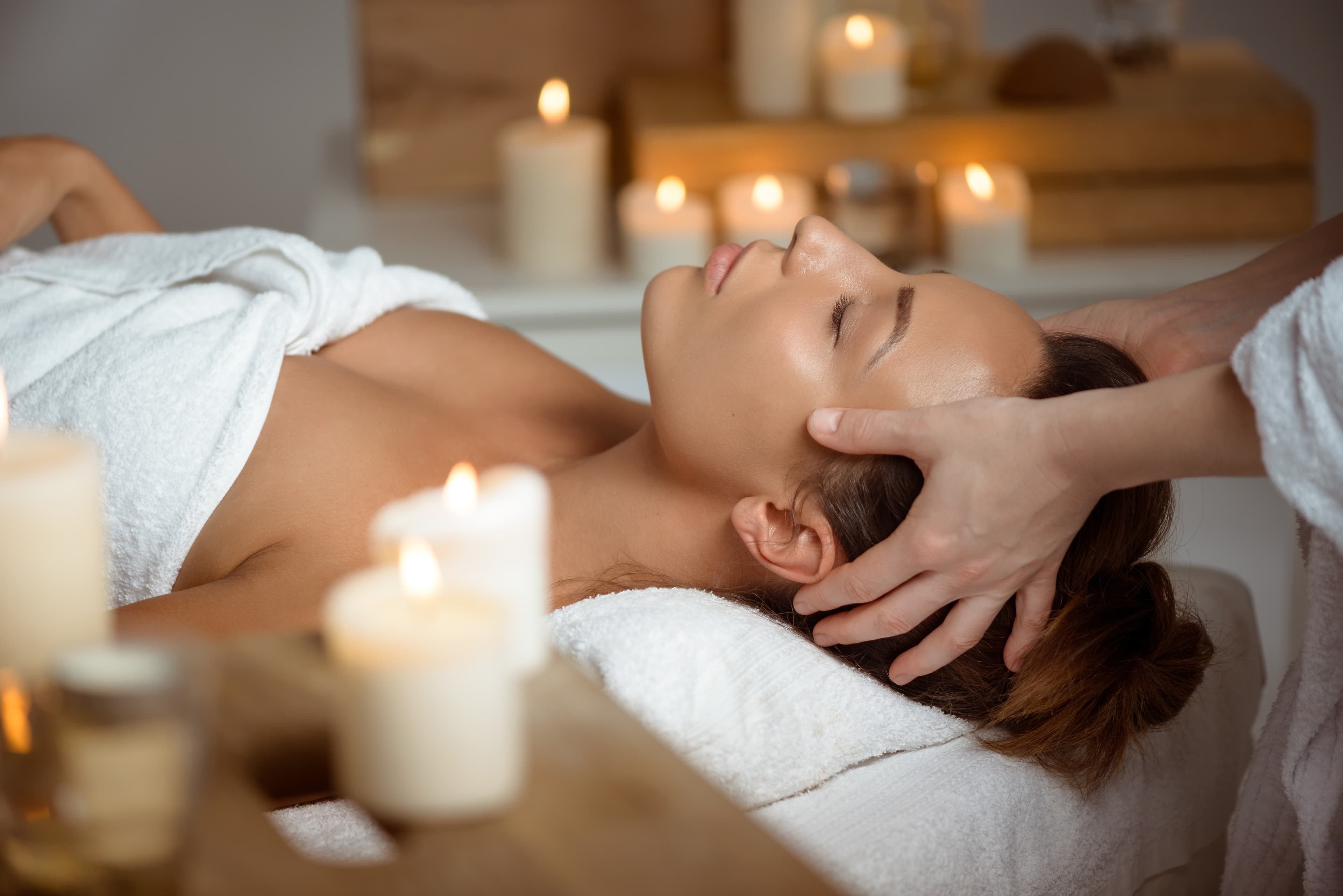 Young woman having face massage relaxing in a spa salon